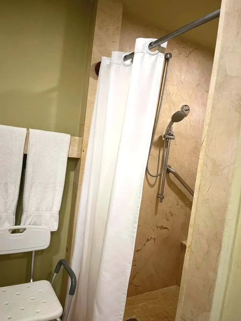 cortina para baño de hotel con toallas blancas